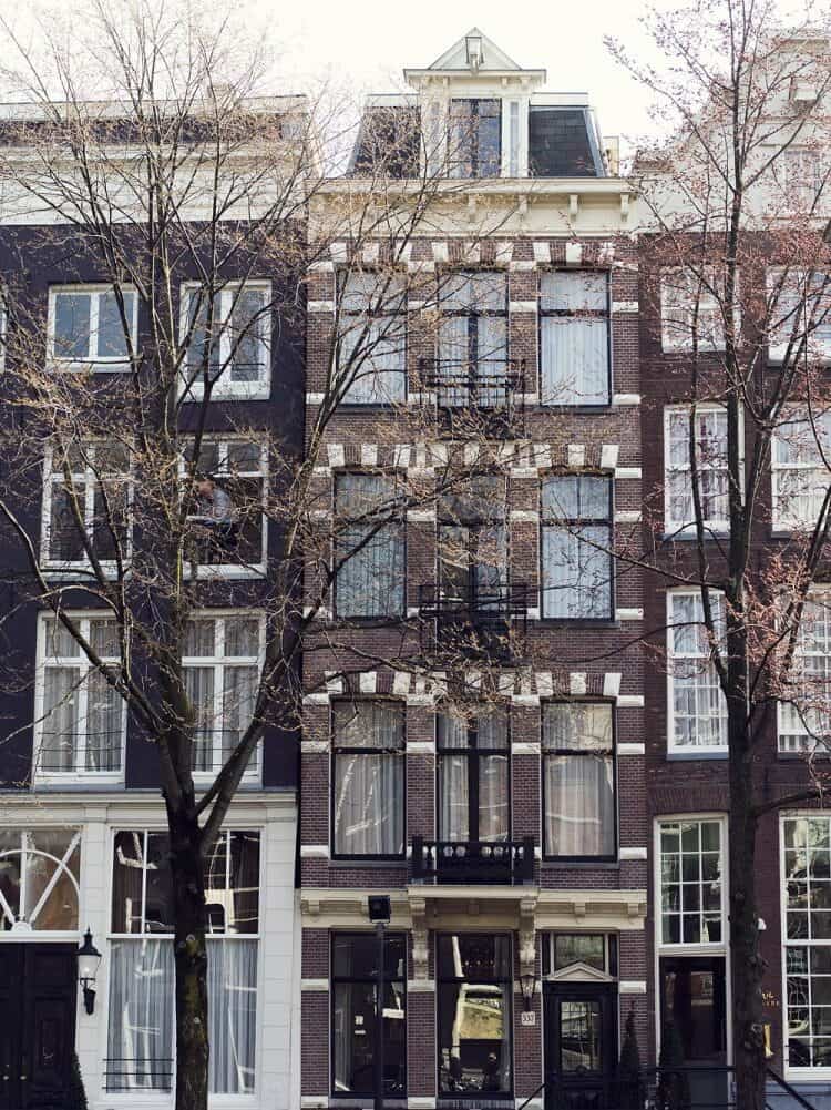 Close up of three buildings side by side in the city centre of Amsterdam in Europe.